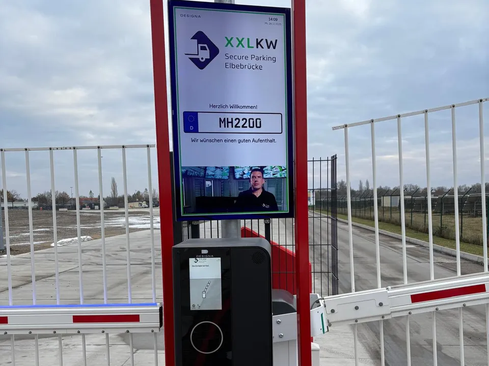 Einfahrt mit Schranke, Check-in-Terminal und Bildschirm mit Kennzeichen-Begrüßung